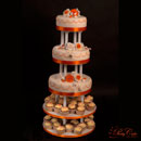 wedding cake with orange and white roses and cupcakes